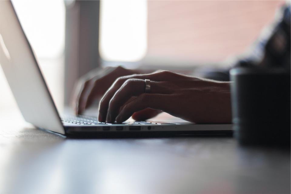 Bàn tay gõ phím laptop, minh họa dùng Copilot trong Excel để làm báo cáo