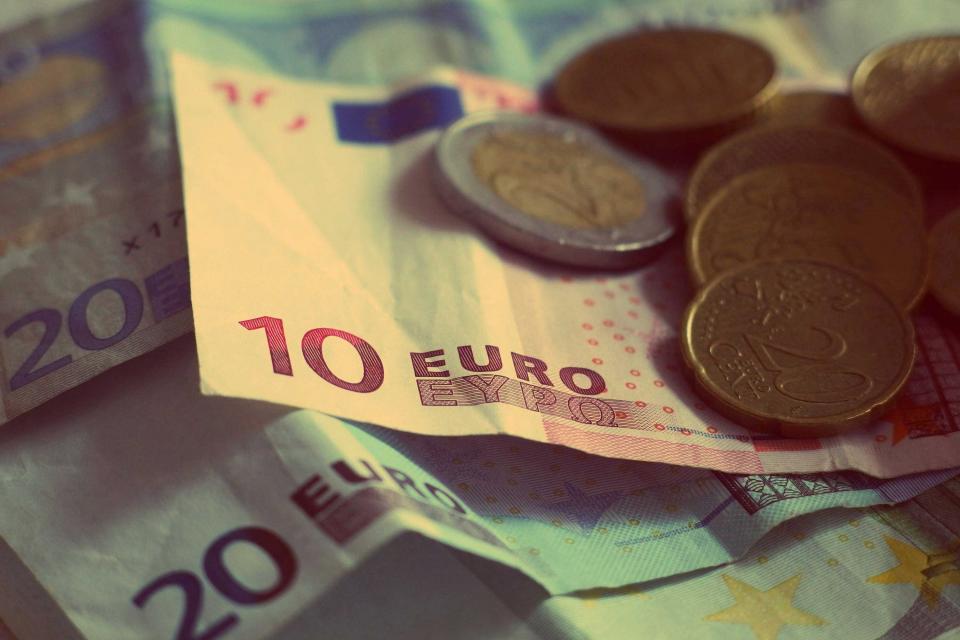 Tờ tiền 10 euro và 20 euro cùng vài đồng xu euro đặt chồng lên nhau