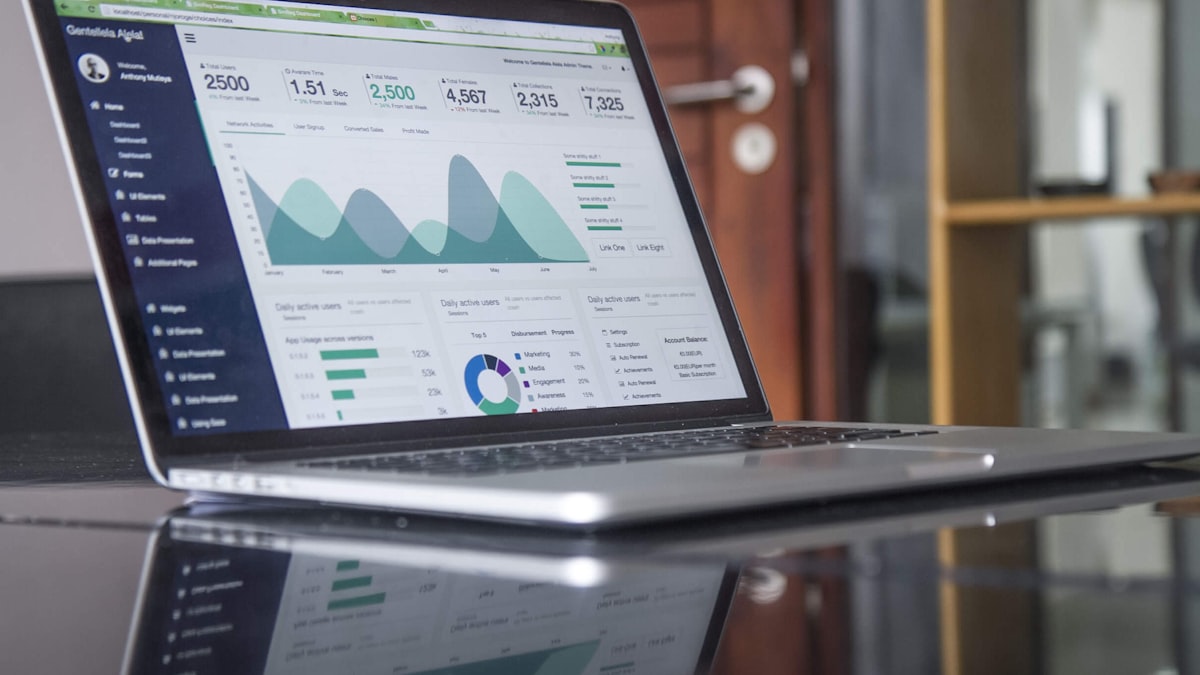 Laptop hiển thị dashboard tài chính với các biểu đồ phân tích số liệu doanh nghiệp
